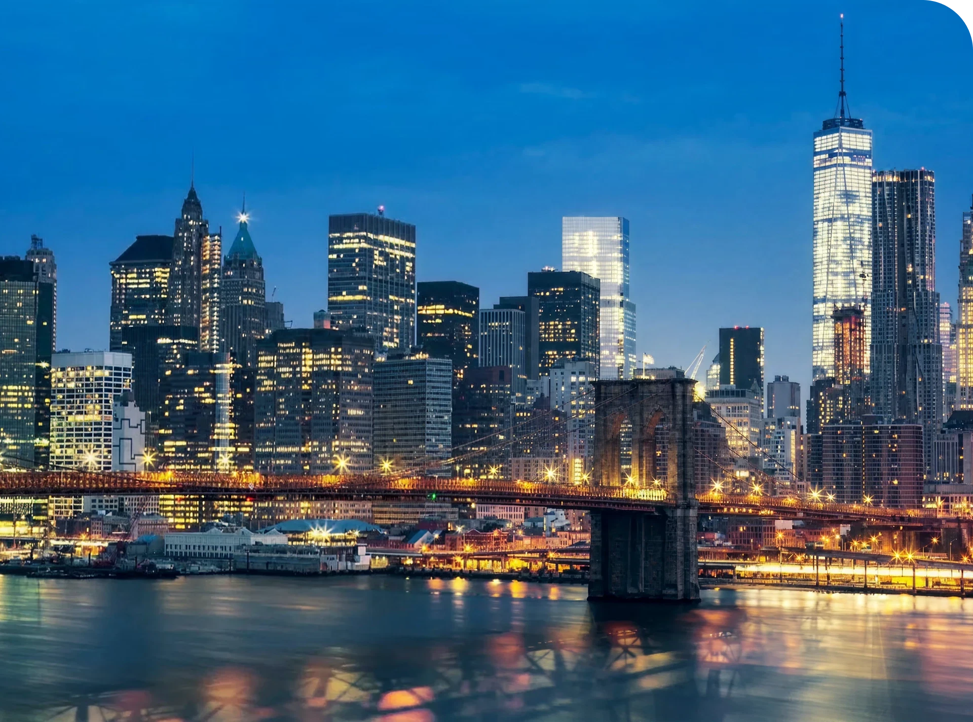 Evening cityscape featuring lit-up buildings and bridge